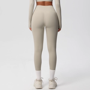 Rear view of high waist seamless yoga leggings and long sleeve cropped top in light beige