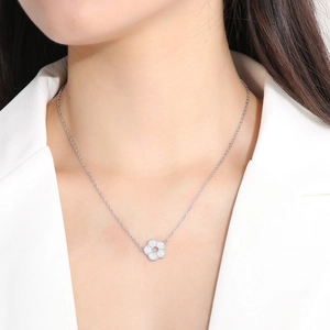 Close-up of a silver flower necklace with sparkling crystals worn by a female model