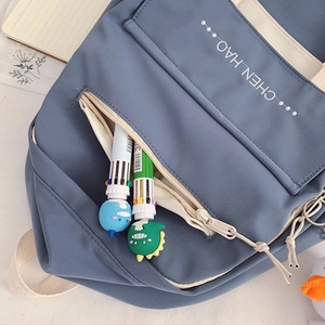 Detail of Morandi blue nylon school bag with cute dinosaur pens and chen_hao printing