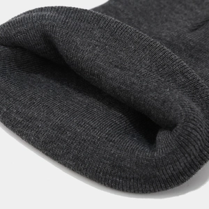Macro view of dark grey knitted fabric texture and folded brim detail on beanie