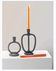 Detail of matte black Nordic metal candle holders with modern geometric textured finish
