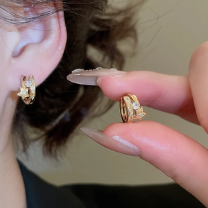 Gros plan de boucles d'oreilles étoiles plaquées or 18k serties de zircons brillants