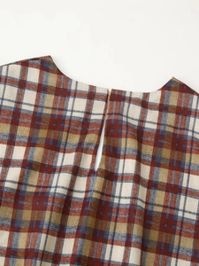 Close-up of the vintage plaid pattern fabric and neckline detail on a mini dress