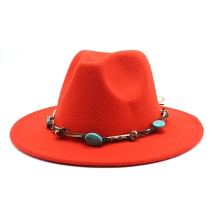 Detail of red wide brim fedora hat featuring turquoise stones and brown braided leather cord