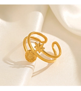 Detail of double-layered 18K gold star and circular disc ring on soft silk fabric