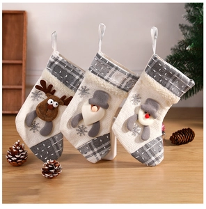 Three grey and white plaid knit Christmas stockings with 3D reindeer, gnome, and snowman