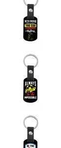 Detail of black leather and metal keychains with engraved motivational football slogans