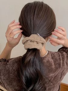 Gros plan d'un chouchou marron tricoté à la main sur les cheveux pour un aspect doux