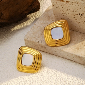 Macro detail of vintage square gold plated earrings with mother of pearl inlay on stone