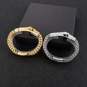 Close-up of rock style gold and silver stainless steel handcuff bracelets on black surface