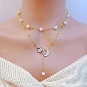 Close-up of double-layer gold necklace with white pearls and star moon pendants