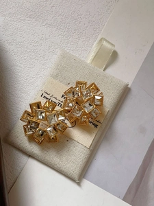 Detailed macro shot of square cubic zirconia stones set in gold floral geometric earrings