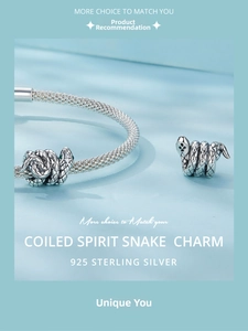 Macro detail of S925 sterling silver snake charm with green gem eyes on mesh bracelet
