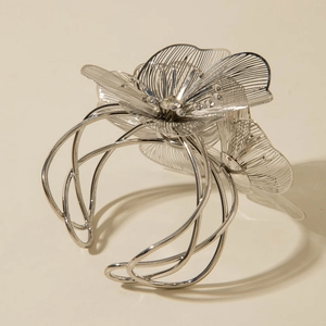 Macro shot of silver filigree mesh flower and sparkling crystals on open cuff bracelet