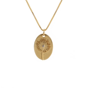Nahaufnahme eines goldenen ovalen Anhängers mit Löwenzahn-Gravur und einem kleinen Zirkon