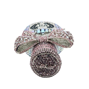 Close-up of luxury skull evening bag with pink crystal bow and sparkling rhinestones