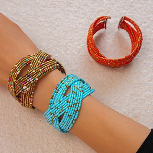 Close-up of bohemian multi-layer seed bead bracelets in turquoise, gold, and red colors