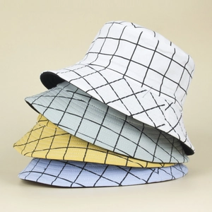 Close-up of stacked plaid bucket hats in white, green, yellow, and light blue canvas