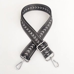 Detailed view of dark grey nylon bag strap with silver arrow pattern and metal buckles