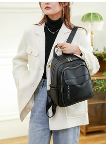 Detail of black PU leather backpack with silver rivets and zippers on a stylish model