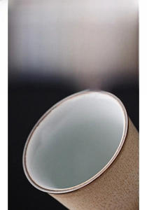 Vue macro d'une tasse à thé en céramique avec bordure métallique et finition mate