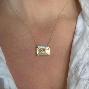 18K gold envelope locket necklace with red heart zircon worn on a female model