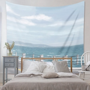 Detail of bohemian wall tapestry featuring a serene blue ocean landscape in a bedroom setting