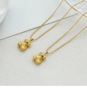 Detailed macro shot of 3D geometric bear pendant necklaces with gold ball chain