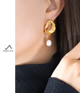 Detail of 18K gold-plated irregular lava earrings with a natural freshwater pearl pendant