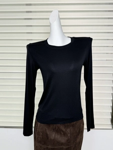 Detail view of black slim-fit wool t-shirt with padded shoulders on a mannequin