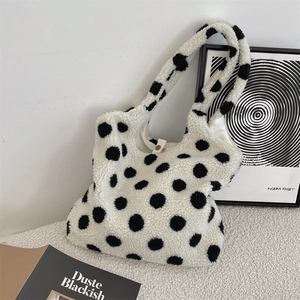 Detailansicht der weißen Plüschtasche mit schwarzen Punkten und breitem Schultergurt
