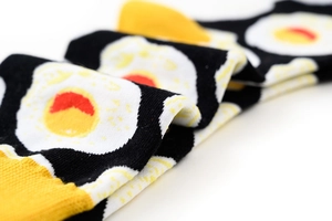 Dettaglio di calze a maglia con motivo a uovo fritto e polsini in cotone giallo