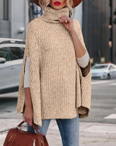 Dettaglio della maglia e collo alto di un elegante maglione a mantella color beige