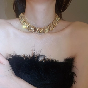 Close-up of a sparkling champagne crystal square link necklace on a model's neck