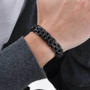 Close-up of minimalist black stainless steel link bracelet worn on a man's wrist