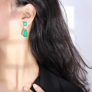 Elegant emerald pear-shaped drop earrings featuring rectangular stones on model