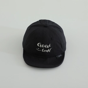 Detail view of a black soft brim baby baseball cap with Good Luck embroidery and smile face
