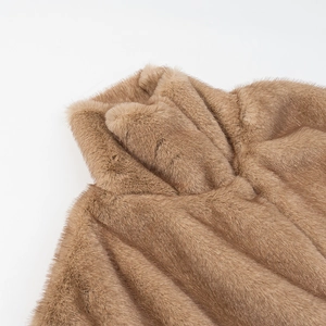 Gros plan sur un gilet en fausse fourrure camel avec col montant et texture pelucheuse
