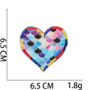 Macro shot of 6.5cm heart embroidery patch with iridescent fish scale texture and red stitching