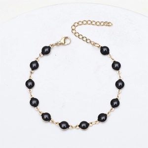 Detail of 18K gold plated stainless steel chain bracelet with black enamel beads