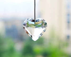 Macro detail of a faceted crystal heart suncatcher prism reflecting natural light