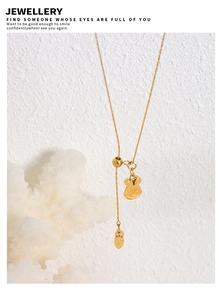 Close-up of golden bunny and carrot pendants on a 18K gold plated stainless steel necklace