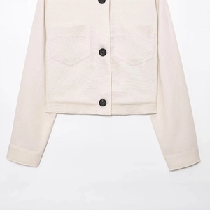 Veste courte en lin beige avec grands boutons noirs et poches symétriques
