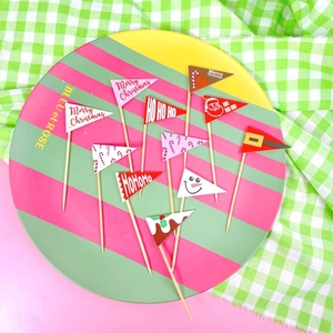 Set of colorful Merry Christmas paper cake toppers with festive patterns on wood sticks