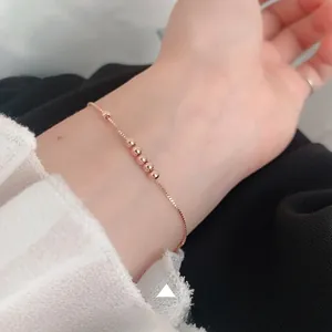 Detailed shot of rose gold beaded bracelet on wrist with adjustable box chain design