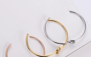 Detail showing knotted open cuffs in gold, silver, and rose gold stainless steel finishes