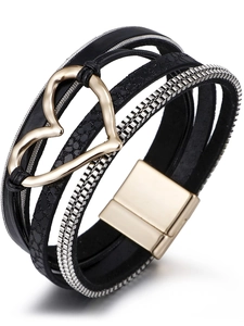 Dettaglio del bracciale multistrato in ecopelle nera con catene argento e chiusura a cuore oro