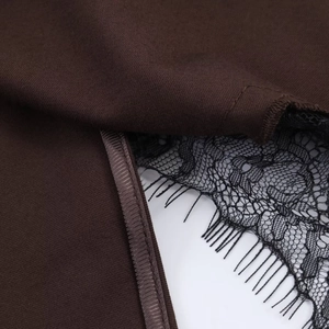 Close-up of dark brown knit fabric with delicate black eyelash lace trim and stitching
