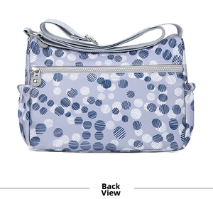 Rear view of purple polka dot nylon crossbody bag with zipper and adjustable strap