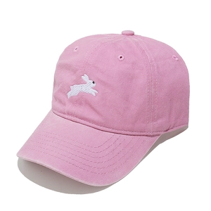 Pink washed cotton baseball cap featuring cute white bunny embroidery in a side profile view